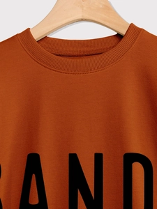 Detail of ribbed crew neck and black AND print on caramel long sleeve sweatshirt