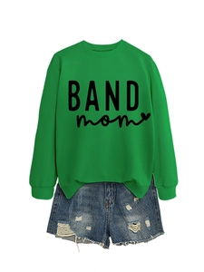 Flat lay of a green long-sleeved BAND mom sweatshirt with distressed denim shorts