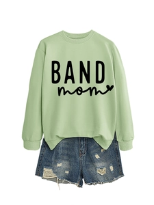 Flat lay detail of a light green long sleeve sweatshirt with BAND mom print and denim shorts