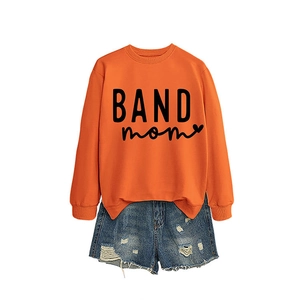Bright orange BAND mom sweatshirt paired with distressed blue denim shorts on white background