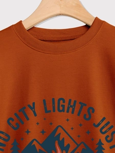 Macro view of rust red sweatshirt neckline with vintage mountain city lights print