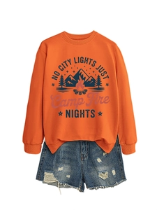 Detail of orange sweatshirt with mountain campfire graphic and denim shorts