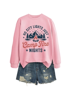 Flat lay of pink camping sweatshirt with campfire print and distressed denim shorts