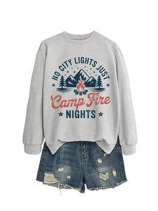 Flat lay of gray sweatshirt with vintage camp fire graphic and distressed denim shorts