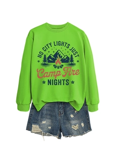 Flat lay of lime green crewneck sweatshirt with camping print and ripped denim shorts