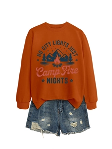 Orange campfire sweatshirt paired with distressed denim shorts for a trendy outdoor look