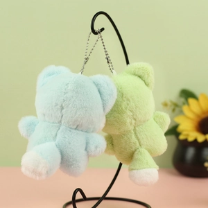 Detail of plush cat keychains in light blue and green with soft faux fur texture