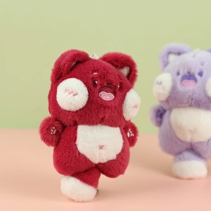 Macro detail of dark red plush cat keychain with white belly and embroidery features