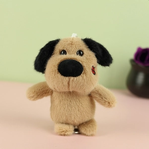 Close-up of plush puppy charm with brown fur, black ears and red heart embroidery