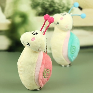 Détail de porte-clés escargots en peluche avec motifs brodés et chaînettes en métal
