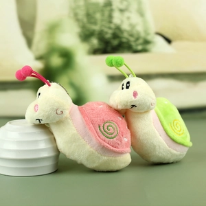 Détail des porte-clés escargots en peluche rose et vert avec broderie en spirale