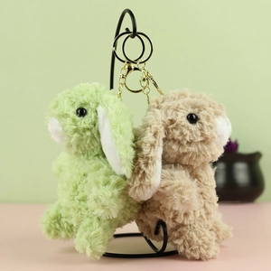 Dettaglio di portachiavi a forma di coniglio in peluche verde e marrone dorato