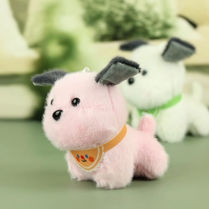 Close-up of pink plush dog keychain with yellow scarf and fuzzy texture detail