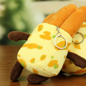 Macro shot of plush bread keychain with soft yellow fabric and silver metal clasp