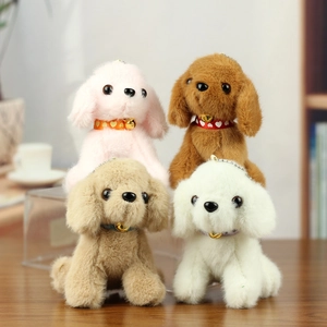 Cute teddy dog plush keychain pendants in assorted colors with bells on wooden surface