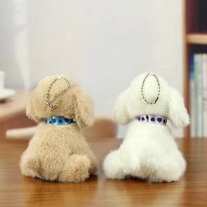 Detail of plush dog keychain with heart collar and silver bead chain in home setting