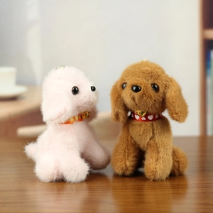 Detailed view of plush dog keychains with red ribbons and golden bells on wooden desk
