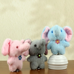 Plush elephant keychains in pink grey and blue with flower detail on wooden table
