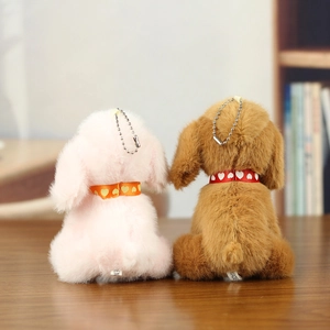 Close-up of pink and brown plush dog charms with heart ribbons and metal bead chains