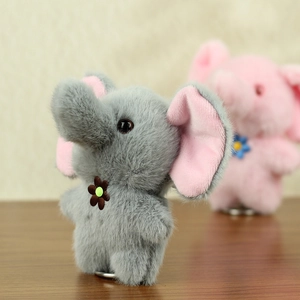 Detail of plush elephant keychains in grey and pink with soft faux fur and floral accents