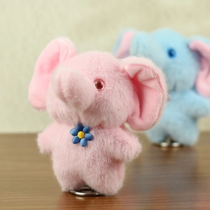 Macro detail of plush elephant doll with blue flower and spring base for car decor