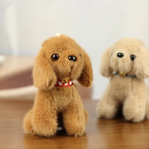 Close-up of cute plush teddy dog charms with red ribbon collars and golden bells