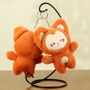 Detail of plush orange fox pendant with fluffy texture and embroidered sleepy facial features