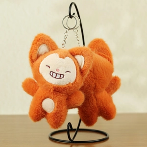 Detail of orange plush fox pendant with embroidery and silver metal keychain ring