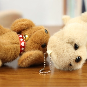 Close-up of cute plush teddy dog keychains with fluffy texture and small bell charms