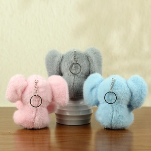 Detailed close-up of colorful plush elephant keychains in pink, grey, and blue colors