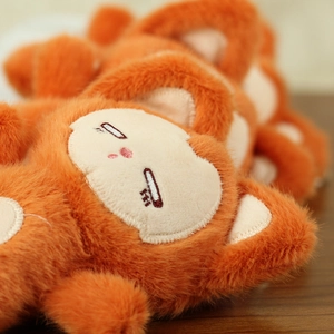 Close-up of orange plush fox with heart-shaped face and delicate closed-eye embroidery