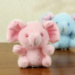 Close-up of pink and blue plush elephant keychains with soft faux fur texture
