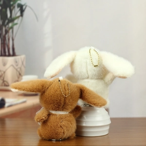 Close-up of soft plush bunny keychain with gold bead chain and silk ribbon detail