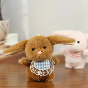 Detail of soft brown plush bunny charm featuring a lace plaid bib and cute bead eyes