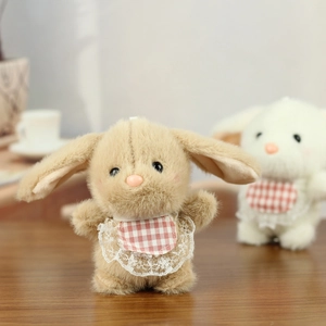 Close-up of cute plush bunny charms in khaki and white with plaid lace bibs