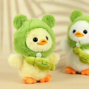 Detail of yellow plush duck wearing a green frog hat and matching crossbody bag charm