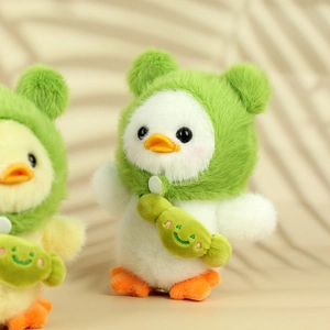 Close-up of plush white duck wearing a green frog hat and a cute smiley face bag