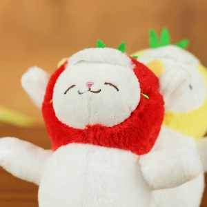 Close-up of cute plush lamb keychain wearing a red strawberry hood with green leaf detail