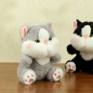 Close-up of cute plush cat keychain with soft fur, pink paw pads, and chubby cheeks