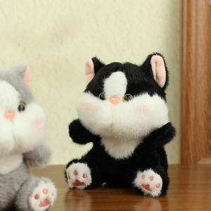 Close-up of cute plush cat keychain showing fluffy soft fur and pink paw embroidery details