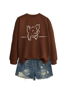 Flat lay of brown long sleeve sweatshirt with white pig print and ripped denim shorts