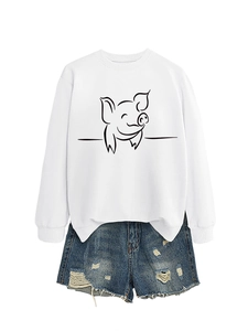 Flat lay of white pig print sweatshirt paired with distressed denim shorts on white background