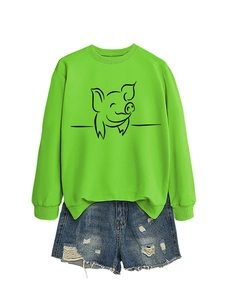 Detail of neon green long sleeve sweatshirt with pig print and ripped denim shorts