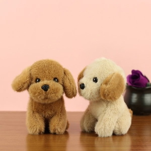 Pendentifs peluches chiots teddy marron et crème sur un bureau en bois