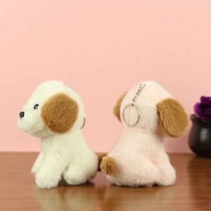 Détail de porte-clés chiots en peluche blanc et rose sur une surface en bois