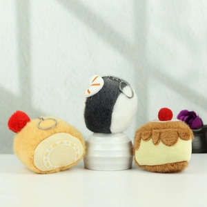 Detail of plush food keychains including burrito, tempura rice, and pudding cake charms
