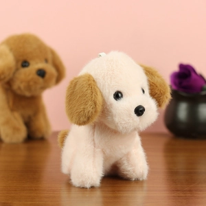 Gros plan d'un adorable porte-clés chiot en peluche beige et marron sur fond rose doux