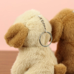 Gros plan sur un porte-clés chiot en peluche beige avec anneau en métal argenté