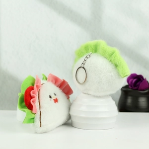 Detail of plush dumpling keychains featuring cute embroidery and metal ring connector