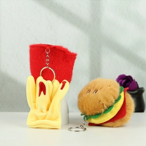 Close-up of cute plush burger and fries charms with metal keychains on a white surface